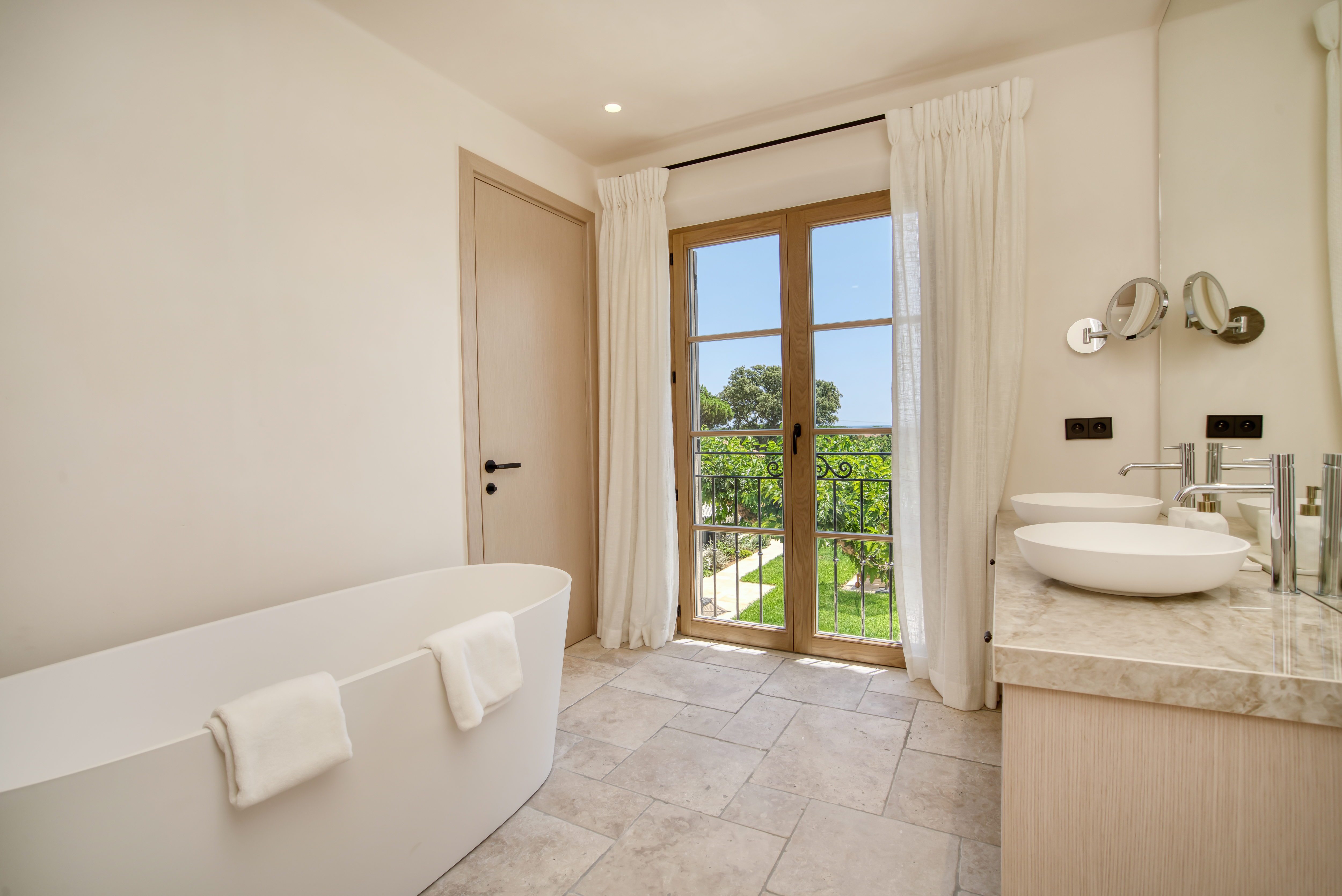 Salle de bain de la Villa Alba avec baignoire et vue jardin