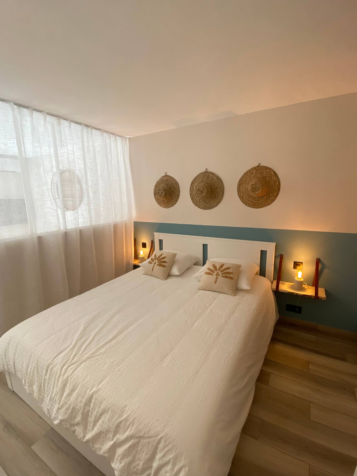 Chambre lumineuse de l'appartement Petit Prince avec linge blanc et décoration murale en fibres naturelles