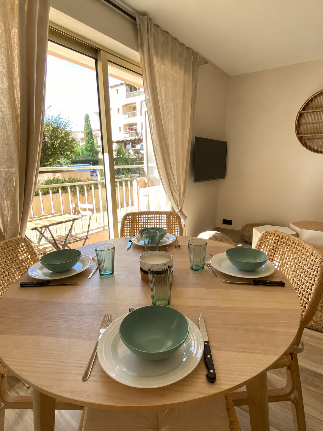 Salle à manger lumineuse de l'appartement Petit Prince avec table dressée et rideaux clairs